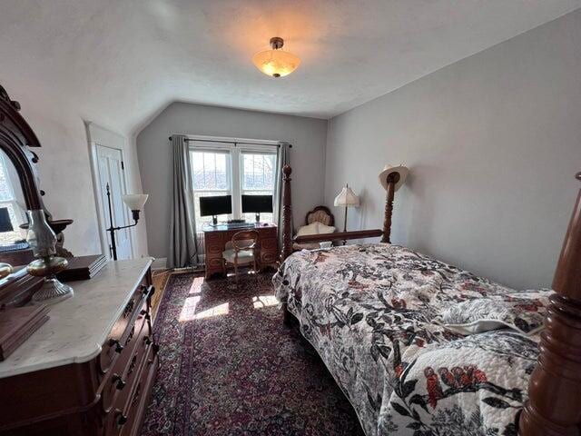 bedroom with granite finish floor and lofted ceiling