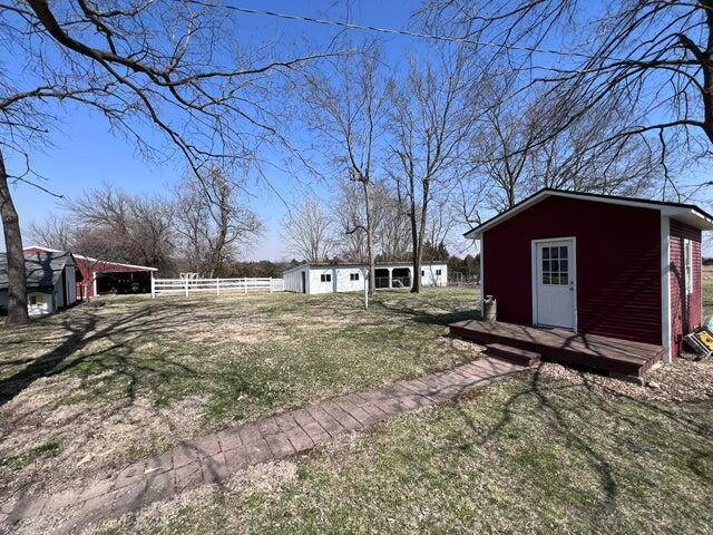 view of yard featuring an outbuilding and fence