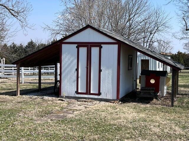 view of outbuilding with an outbuilding, fence, and a carport