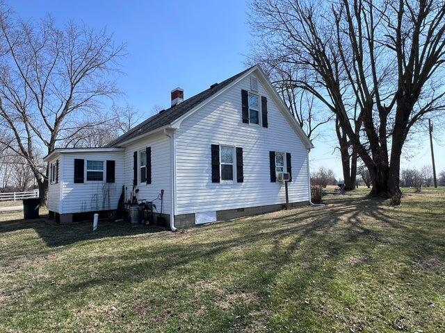 view of side of home with a yard and a chimney