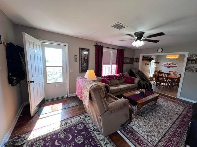 living room featuring visible vents, plenty of natural light, a ceiling fan, and wood finished floors