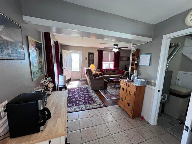 living room featuring light tile patterned flooring and ceiling fan