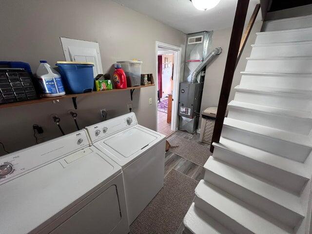 clothes washing area featuring visible vents, separate washer and dryer, wood finished floors, and laundry area