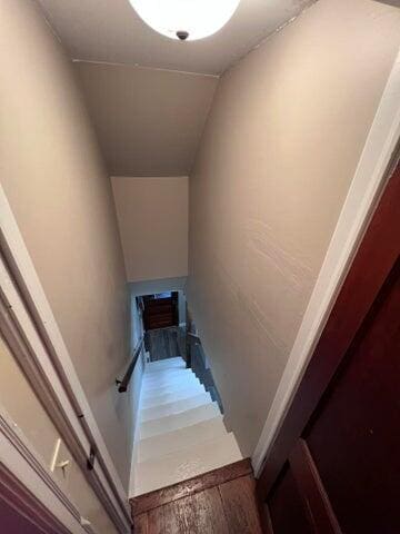 stairway featuring wood finished floors and vaulted ceiling