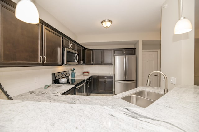 kitchen with light stone counters, a sink, decorative backsplash, dark brown cabinetry, and stainless steel appliances