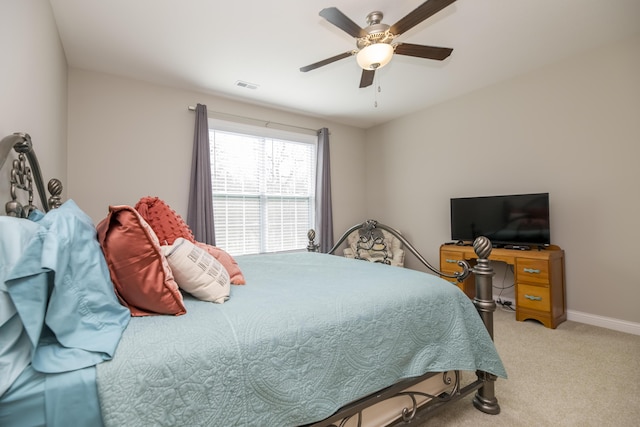 bedroom with ceiling fan, light colored carpet, visible vents, and baseboards