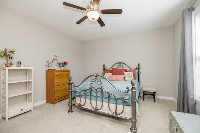 bedroom with a ceiling fan, multiple windows, light colored carpet, and baseboards