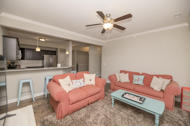 living area with light wood finished floors, a ceiling fan, and ornamental molding