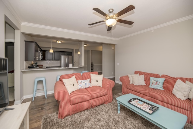 living area featuring baseboards, crown molding, a ceiling fan, and wood finished floors