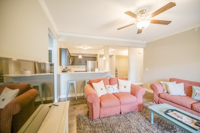 living area with wood finished floors, baseboards, ceiling fan, and ornamental molding