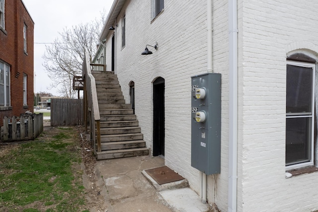 view of property exterior with stairway and brick siding