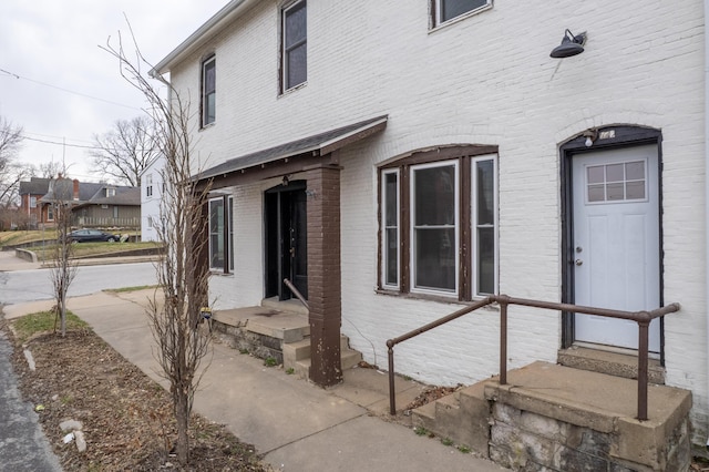 entrance to property featuring brick siding