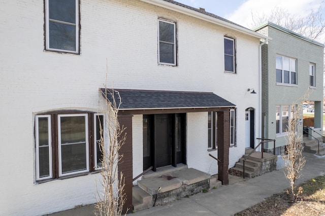 rear view of house featuring brick siding and entry steps