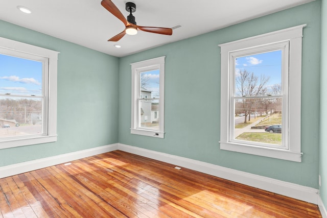 unfurnished room featuring visible vents, ceiling fan, baseboards, and wood-type flooring