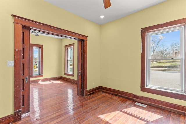 unfurnished room featuring wood finished floors, visible vents, baseboards, recessed lighting, and ceiling fan