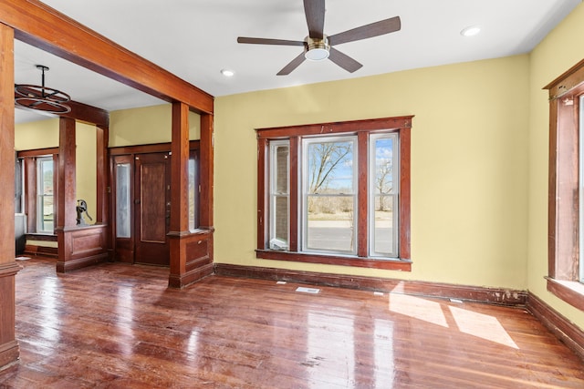 interior space with ceiling fan, baseboards, plenty of natural light, and wood finished floors