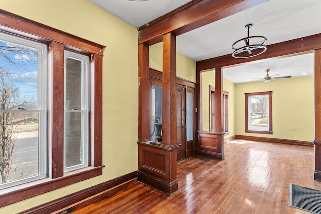 hall featuring beamed ceiling, baseboards, visible vents, and dark wood finished floors