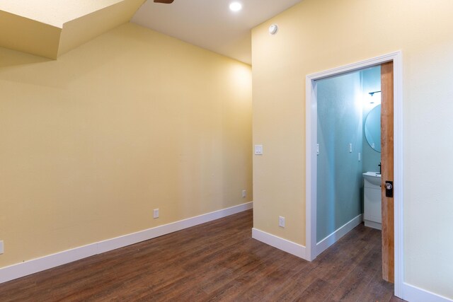 interior space featuring baseboards, dark wood-type flooring, and vaulted ceiling