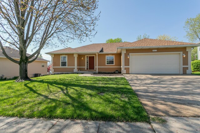 4612 Manhasset Dr, Columbia, MO 65203 - ranch-style house featuring stucco siding, an attached garage, driveway, and a front yard