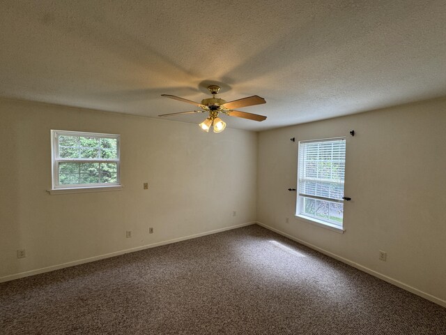 6112 E Forsee Rd, Ashland, MO 65010 - spare room featuring a ceiling fan, a textured ceiling, dark carpet, and baseboards