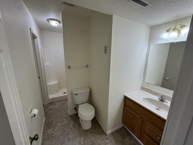 6112 E Forsee Rd, Ashland, MO 65010 - full bathroom featuring a textured ceiling, toilet, vanity, a walk in shower, and baseboards