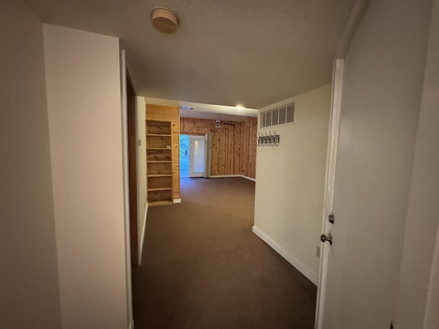 6112 E Forsee Rd, Ashland, MO 65010 - hallway with wood walls, dark colored carpet, and baseboards
