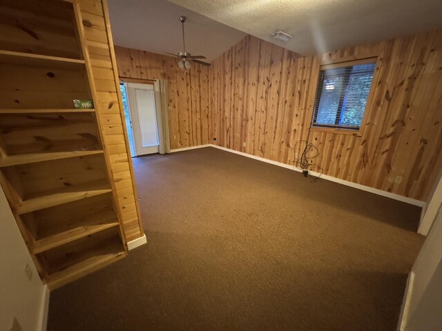 6112 E Forsee Rd, Ashland, MO 65010 - spare room with wooden walls, carpet, ceiling fan, baseboards, and a textured ceiling