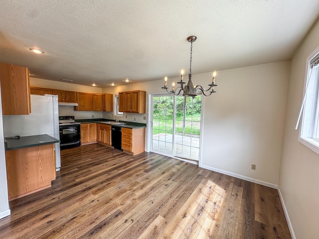 6132 E Forsee Rd, Ashland, MO 65010 - kitchen with black appliances, dark wood-type flooring, a chandelier, baseboards, and dark countertops