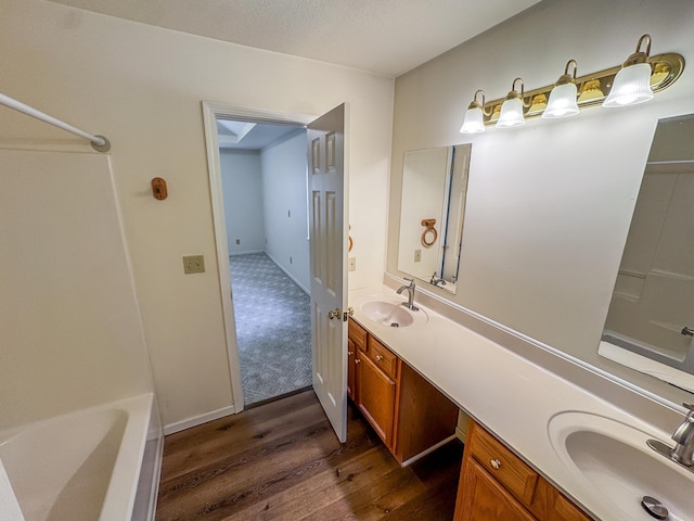 6132 E Forsee Rd, Ashland, MO 65010 - full bathroom featuring a sink, double vanity, a bathtub, and wood finished floors