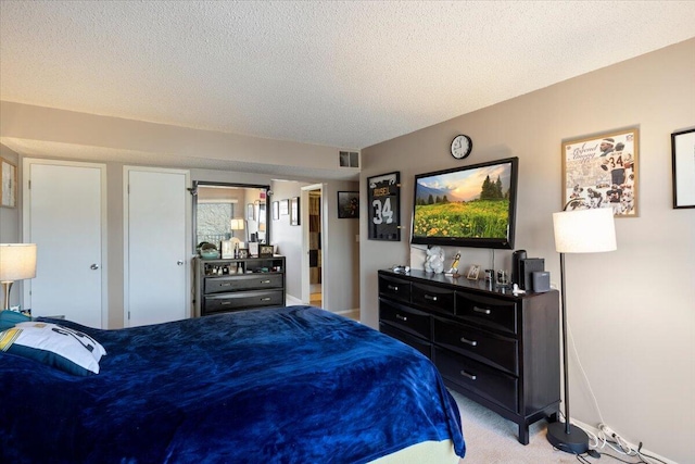 bedroom with visible vents, light carpet, and a textured ceiling