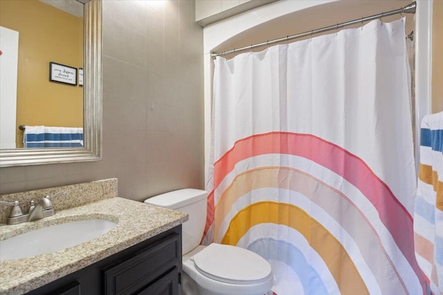 full bath with tile walls, toilet, vanity, and a shower with curtain