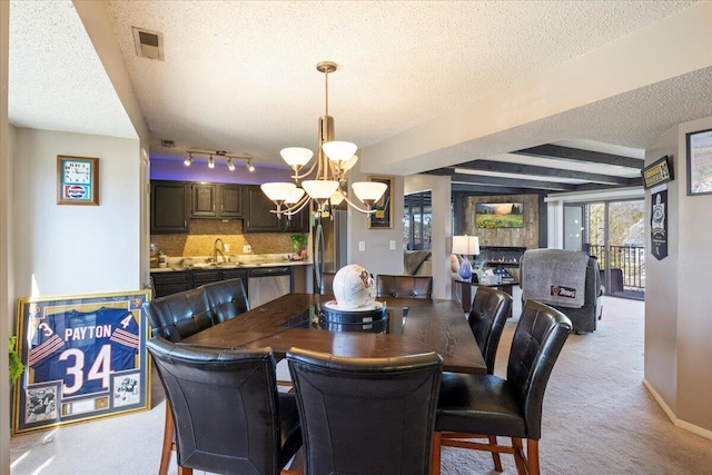 dining room featuring light colored carpet, a textured ceiling, a chandelier, and visible vents