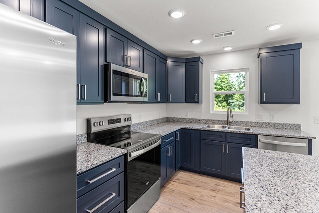 35 Andy Ct, Clark, MO 65243 - kitchen with stainless steel appliances, light wood finished floors, recessed lighting, light stone counters, and blue cabinetry