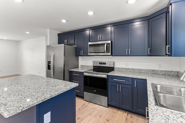 35 Andy Ct, Clark, MO 65243 - kitchen with appliances with stainless steel finishes, blue cabinets, light wood-style flooring, light stone counters, and recessed lighting