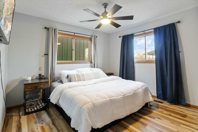 28489 Possum Trot Rd, Stover, MO 65078 - bedroom featuring baseboards, a textured ceiling, wood finished floors, and ceiling fan