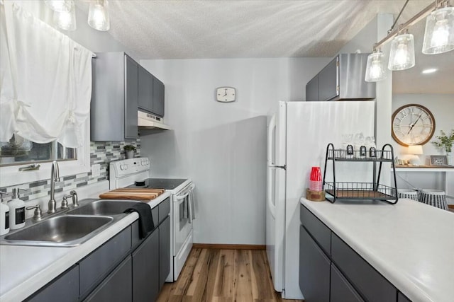 28489 Possum Trot Rd, Stover, MO 65078 - kitchen featuring light countertops, white appliances, wood finished floors, tasteful backsplash, and a sink
