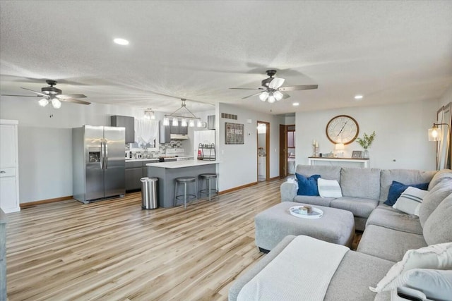 28489 Possum Trot Rd, Stover, MO 65078 - living room with a textured ceiling, a ceiling fan, and light wood finished floors