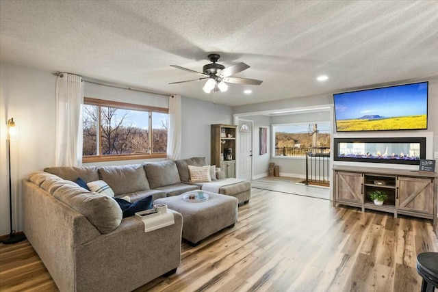 28489 Possum Trot Rd, Stover, MO 65078 - living area with a textured ceiling, baseboards, wood finished floors, recessed lighting, and a ceiling fan