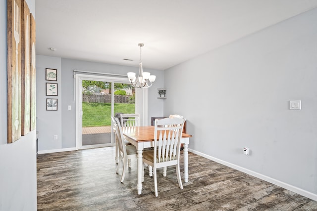 dining room with baseboards, wood finished floors, and an inviting chandelier