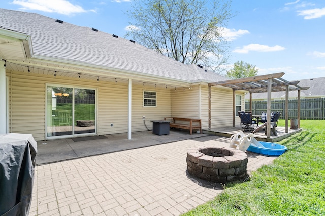 back of property featuring a fire pit, roof with shingles, a pergola, and fence