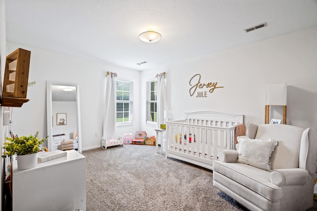 bedroom with carpet floors, baseboards, a nursery area, and visible vents