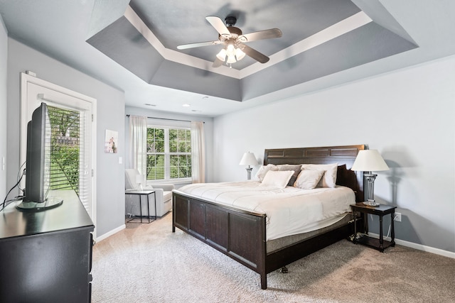 bedroom featuring a ceiling fan, baseboards, light carpet, and a raised ceiling