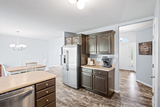 kitchen featuring dark wood finished floors, dark brown cabinets, light countertops, a chandelier, and stainless steel appliances