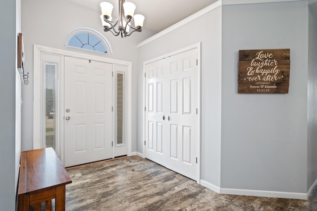 foyer featuring baseboards, wood finished floors, and a notable chandelier