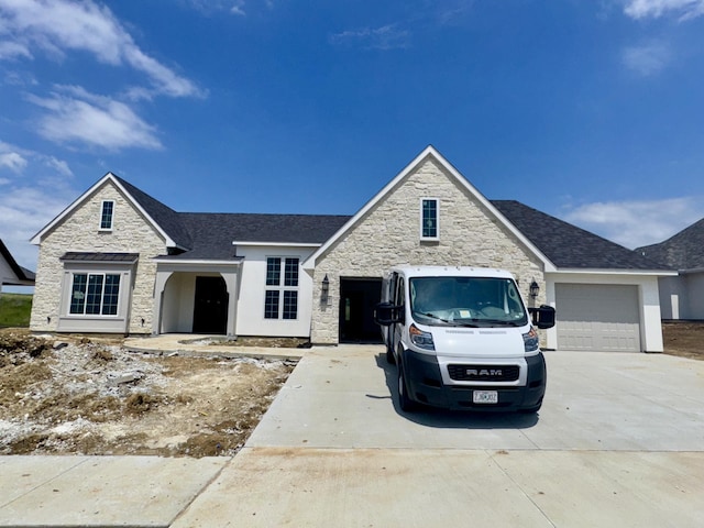 view of front of property with stone siding, concrete driveway, and a garage
