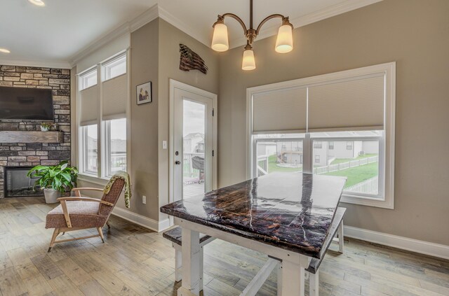 4716 Emeribrook Ct, Columbia, MO 65203 - dining room featuring crown molding, baseboards, light wood finished floors, and a stone fireplace