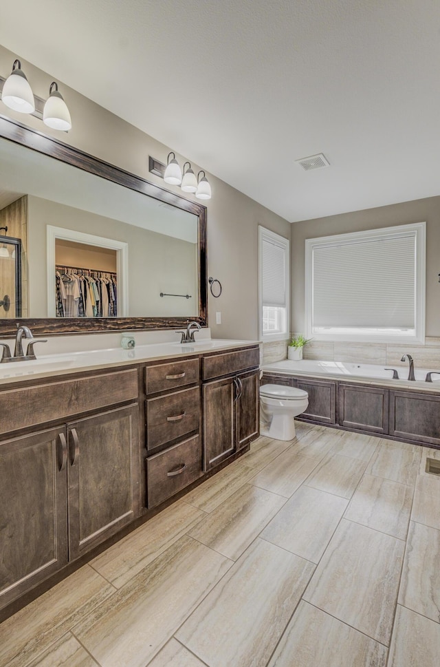 4716 Emeribrook Ct, Columbia, MO 65203 - full bath with visible vents, a bath, a sink, a spacious closet, and double vanity