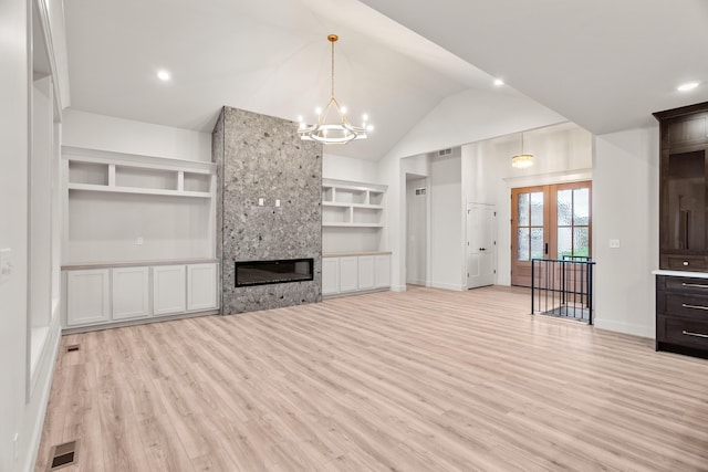 unfurnished living room featuring an inviting chandelier, light wood-style floors, built in shelves, baseboards, and visible vents