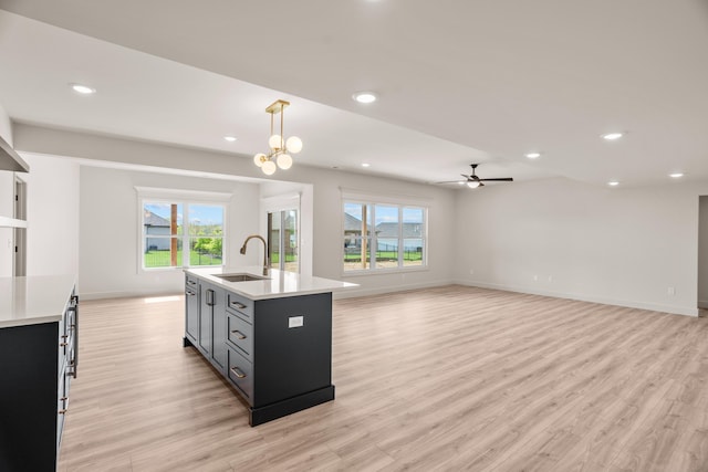 kitchen featuring a sink, light wood finished floors, and light countertops