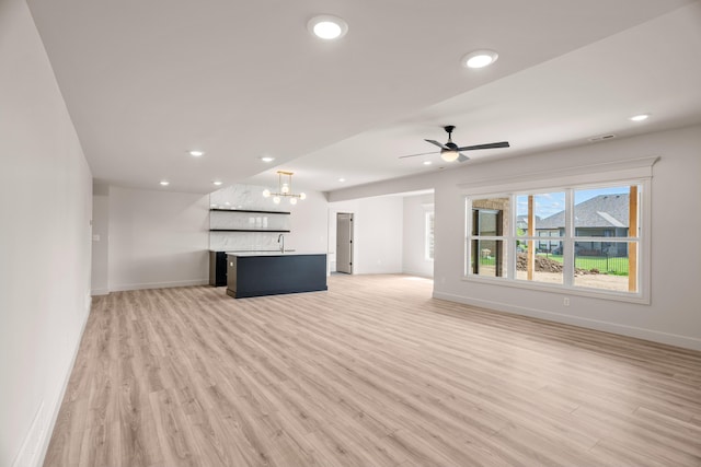 unfurnished living room with baseboards and light wood finished floors